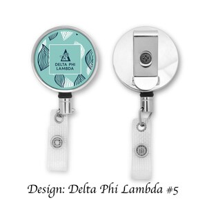 Könnte beinhalten: Ein silberner ausziehbarer Ausweishalter mit einem runden, blaugrünen Design, das ein weißes Dreieck mit dem Text "Delta Phi Lambda" enthält. Das Design enthält auch weiße und blaue Blattmotive.