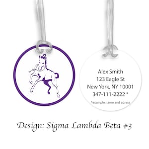 May include: Purple luggage tag with a white silhouette of a horse on one side and text on the other side that reads: "Alex Smith, 123 Eagle St, New York, NY 10001, 347-111-2222 *example name and address". The text "Design: Sigma Lambda Beta #3" is below the tag.