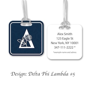 May include: Two luggage tags. One tag is navy blue with a white Delta symbol and rose design. The other tag is white with the text "Alex Smith, 123 Eagle St, New York, NY 10001, 347-111-2222 *" and "*example name and adress".