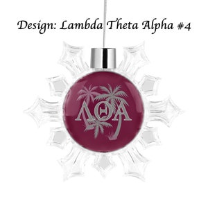May include: A clear snowflake ornament with a maroon center. The center features palm trees and the Greek letters ΛΘA in silver. The text "Design: Lambda Theta Alpha #4" is above the ornament.