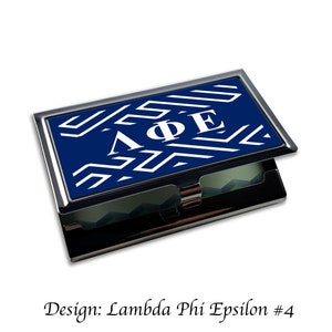 May include: A blue and white business card holder with a geometric pattern and the letters "ΛΦΕ" in white.