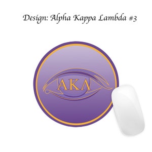 Pode incluir: Mousepad redondo roxo e dourado com um design de olho e as letras "AKA" dentro. O mousepad est&aacute; em uma superf&iacute;cie branca.