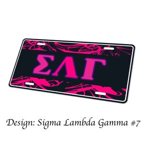 May include: Black and pink license plate with the Greek letters Sigma Lambda Gamma. The letters are in a pink font with a purple outline. The background is black with a pink abstract design.