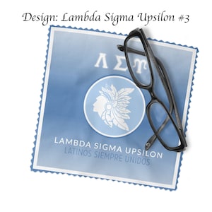 May include: A blue and white design with the text "Lambda Sigma Upsilon Latinos Siempre Unidos" and the Greek letters "&Lambda;&Sigma;&Upsilon;" on a blue background. A pair of black spectacles is on top of the design.