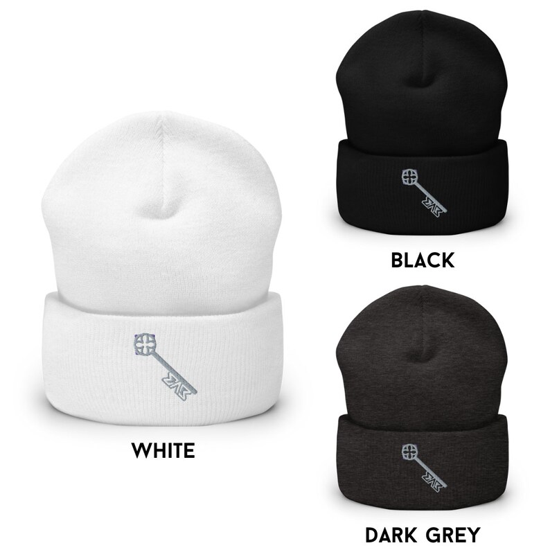 Pu&ograve; includere: Tre berretti in diversi colori: bianco, nero e grigio scuro. Ogni berretto presenta una chiave argentata con un design a croce e il testo "ZAK" ricamato sul davanti.