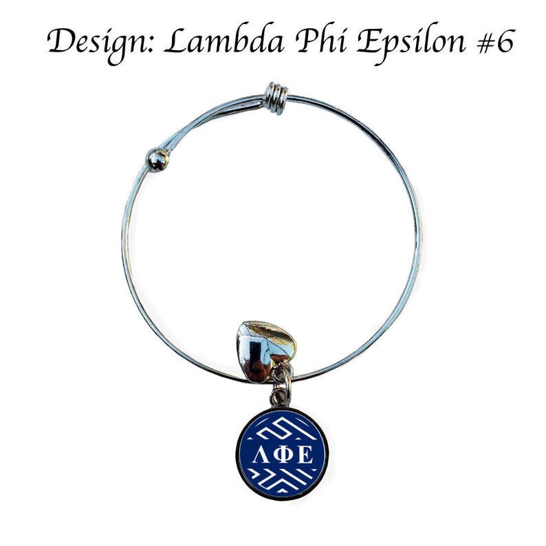 May include: A silver expandable bracelet with a blue and white charm featuring the Greek letters "&Lambda;&Phi;&Epsilon;" in white. The charm is round and has a white geometric pattern.