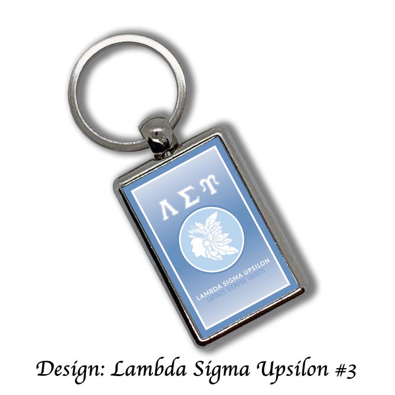 May include: Silver rectangular keychain with a light blue background. The keychain features the Greek letters &Lambda;&Sigma;&Upsilon; in white, a circular emblem with a profile and text that reads "Lambda Sigma Upsilon Latinos Siempre Unidos". The design is "Lambda Sigma Upsilon #3".