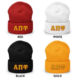 K&ouml;nnte beinhalten: Vier Strickm&uuml;tzen in verschiedenen Farben mit den Buchstaben "&Lambda;&Pi;&Pi;&Gamma;" in Gelb auf der Vorderseite gestickt. Die M&uuml;tzen sind rot, wei&szlig;, schwarz und gold.