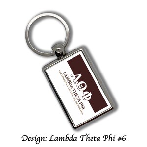 May include: Silver rectangular keychain with a Lambda Theta Phi design. The design features the Greek letters ΛΘΦ in white on a dark brown background, with the text "FRATERNIDAD LATINA, INCORPORADA". The text "Design: Lambda Theta Phi #6" is at the bottom.