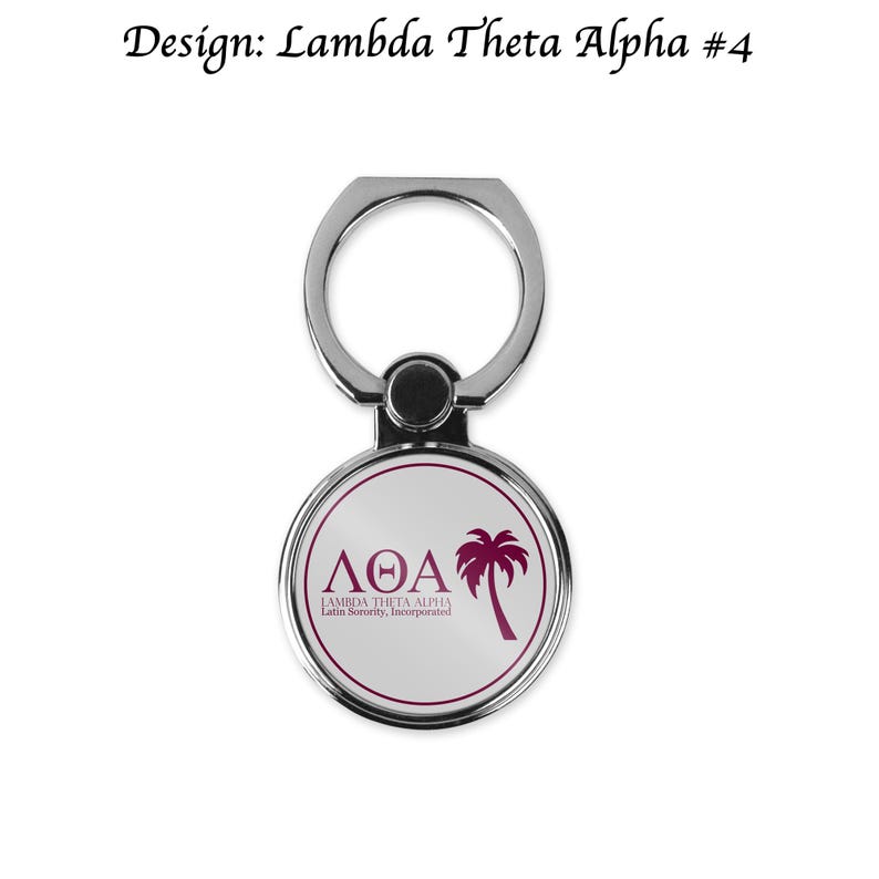 Op de afbeelding: Een zilveren telefoonringhouder met een witte cirkel met een roze palmboom en de tekst "&Lambda;&Theta;&Alpha; LAMBDA THETA ALPHA Latin Sorority, Incorporated".