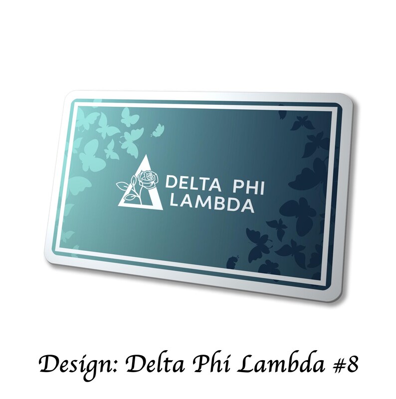 May include: A rectangular teal and white design with the text "DELTA PHI LAMBDA". The design features a white triangle with a rose and butterfly silhouettes. The words "Design: Delta Phi Lambda #8" are at the bottom.