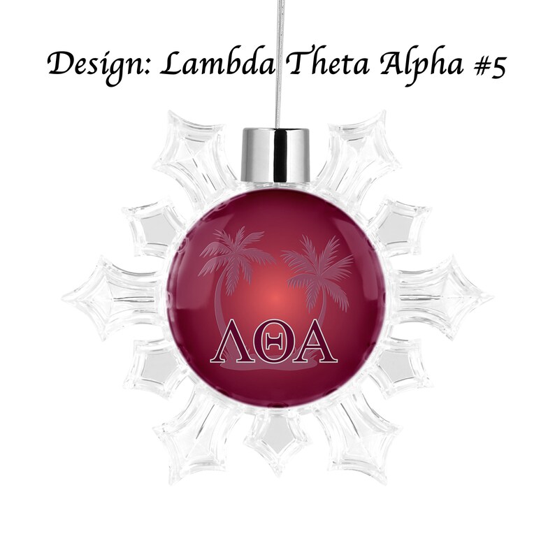 K&ouml;nnte beinhalten: Ein Weihnachtsschmuck mit einem weinroten Mittelteil mit Palmen und den griechischen Buchstaben &Lambda;&Theta;A. Der Schmuck ist von einem transparenten Schneeflocken-Design umgeben und tr&auml;gt oben den Text "Design: Lambda Theta Alpha #5".