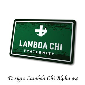 May include: A rectangular green sign with white text and a white cross symbol. The sign reads "LAMBDA CHI FRATERNITY" in bold white letters. The design is labeled "Design: Lambda Chi Alpha #4" in a cursive font.