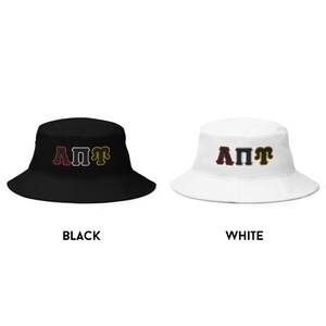 May include: Black and white bucket hats with the letters "A&Pi;&Pi;&Gamma;" in red, gray, and gold. The hats are available in black and white.