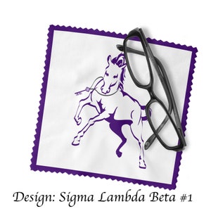 Może przedstawiać: Fioletowy ściereczka z mikrofibry z białym logo konia i tekstem "Sigma Lambda Beta #1". Na ściereczce leży para czarnych okular&oacute;w.
