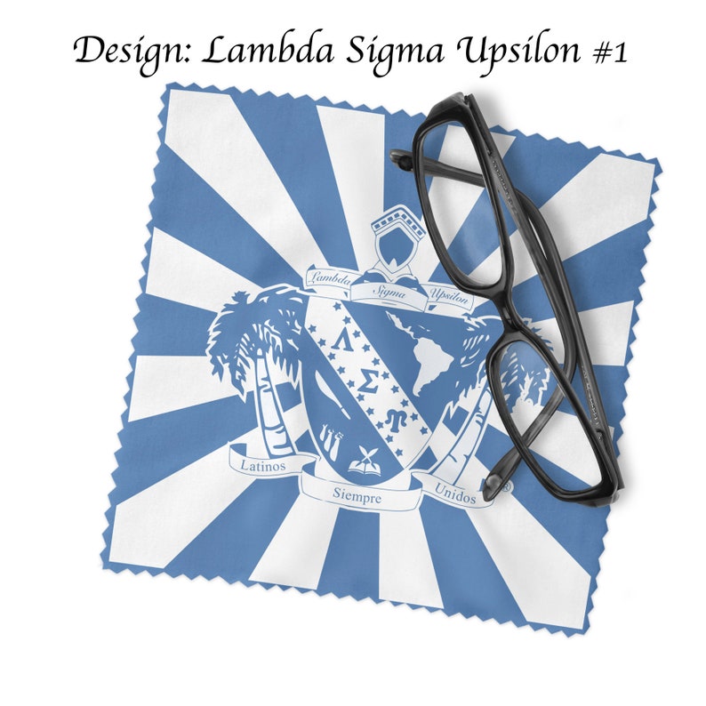 May include: A blue and white microfiber cleaning cloth with a fraternity crest featuring a globe, palm trees, and the text "Lambda Sigma Upsilon" and "Latinos Unidos Siempre". A pair of black eyeglasses is on top of the cloth.