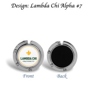 以下が含まれることがあります： 丸いデザインのシルバーカラーのバッグフック。前面には、白と黄色の背景にLambda Chi Fraternityのロゴが表示されています。背面は無地の黒です。「Design: Lambda Chi Alpha #7」の文字が上部にあります。