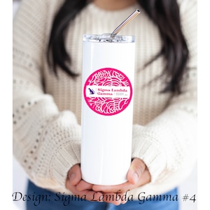 May include: White stainless steel tumbler with a pink and white floral design and the text "Sigma Lambda Gamma National Sorority, Inc."