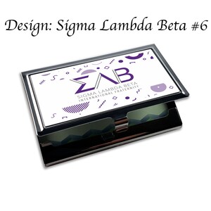 Puede incluir: Un porta tarjetas de plata con un dise&ntilde;o blanco que presenta las letras "&Sigma;&Alpha;&Beta;" y el texto "Sigma Lambda Beta International Fraternity". El dise&ntilde;o tambi&eacute;n incluye formas geom&eacute;tricas en morado y negro.