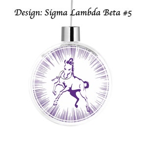 Puede incluir: Un adorno de Navidad de vidrio transparente con una parte superior plateada y un dise&ntilde;o de caballo morado. El caballo est&aacute; en una pose de carrera con una cuerda morada alrededor del cuello. El adorno tiene un fondo blanco con l&iacute;neas moradas que irradian desde el centro.