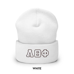 May include: White beanie hat featuring the Greek letters &Lambda;&Theta;&Phi; in brown. The word "WHITE" is printed in a bold, sans-serif font at the bottom of the hat.