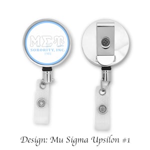 May include: A silver retractable badge reel with a round, white and light blue design featuring the letters "MΣΓ" and the text "SORORITY, INC. 1981".