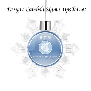 May include: A blue and white snowflake ornament with the Greek letters Lambda Sigma Upsilon and the text "Lambda Sigma Upsilon Latinos Siempre Unidos".