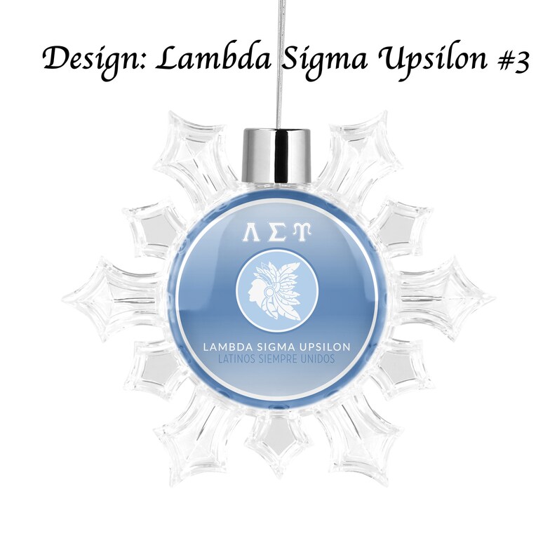 May include: A blue and white snowflake ornament with the Greek letters Lambda Sigma Upsilon and the text "Lambda Sigma Upsilon Latinos Siempre Unidos".