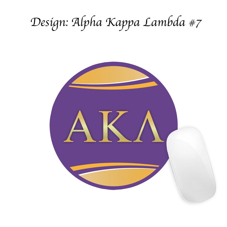 Pode incluir: Um tapete de rato redondo de cor roxa com um logotipo "AKA" dourado e um design dourado e branco. O tapete de rato est&aacute; sobre um fundo branco.