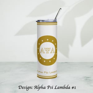 Könnte beinhalten: Ein weißer Becher mit einem goldenen Design mit den griechischen Buchstaben A, Ψ und Λ in einem goldenen Kreis mit Sternen. Der Becher hat einen goldenen Rand und der Text "Alpha Psi Lambda" ist darunter gedruckt. Ein silberner Strohhalm ist im Deckel eingesetzt.
