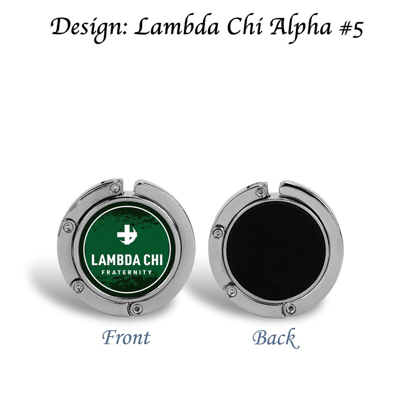 以下が含まれることがあります： 前面に緑と白のLambda Chi Alpha Fraternityのロゴ、裏面に黒い面が付いたシルバーカラーのバッグフック。「Design: Lambda Chi Alpha #5」、「Front」、「Back」の文字も表示されています。