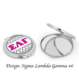 Op de afbeelding: Een zilveren compact spiegel met een witte achtergrond en een grijs geometrisch patroon. De letters "&Sigma;&Lambda;&Gamma;" staan in roze op de voorkant van de spiegel. De spiegel is in de eerste afbeelding gesloten en in de tweede afbeelding open. Ontwerp: Sigma Lambda Gamma #6