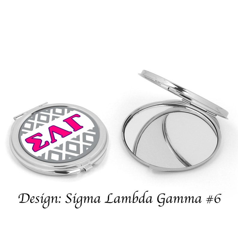 Op de afbeelding: Een zilveren compact spiegel met een witte achtergrond en een grijs geometrisch patroon. De letters "&Sigma;&Lambda;&Gamma;" staan in roze op de voorkant van de spiegel. De spiegel is in de eerste afbeelding gesloten en in de tweede afbeelding open. Ontwerp: Sigma Lambda Gamma #6