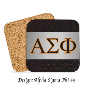 Könnte beinhalten: Ein Set aus zwei Korkuntersetzern mit einem schwarzen und braunen geometrischen Muster. Der obere Untersetzer zeigt ein silbernes Rechteck mit den Buchstaben "ΑΣΦ" in Orange und Schwarz.