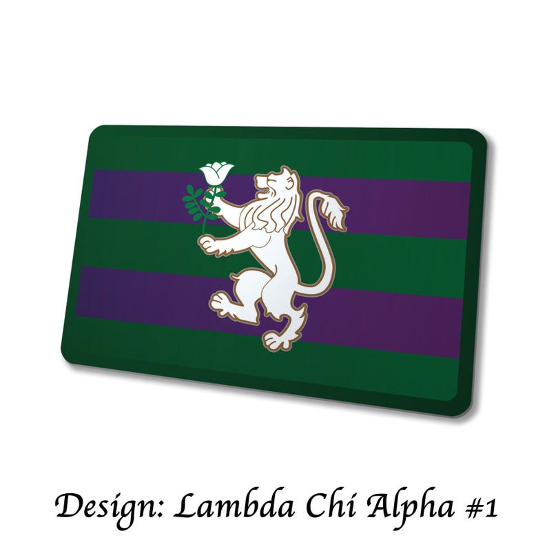 May include: Rectangular green and purple design with a white lion holding a white flower. The text "Design: Lambda Chi Alpha #1" is at the bottom. The design has a green background with two purple stripes.