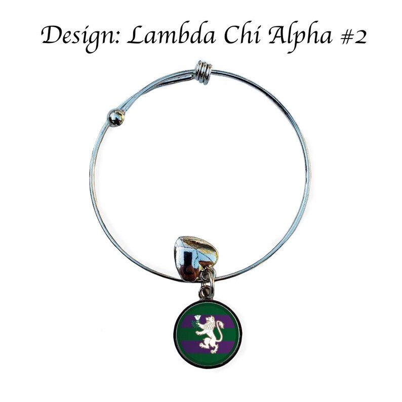 Puede incluir: Un brazalete extensible de plata con un dije que presenta un c&iacute;rculo verde y morado con un le&oacute;n blanco y una flor blanca. El dije est&aacute; unido a un dije de coraz&oacute;n plateado. El brazalete est&aacute; etiquetado como "Dise&ntilde;o: Lambda Chi Alpha #2".
