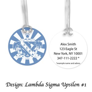 Op de afbeelding: Twee bagagelabels. Eén is lichtblauw met een wit ontwerp en de tekst "Latinos Siempre Unidos". De andere is wit met de naam "Alex Smith" en adresinformatie. Het ontwerp is "Lambda Sigma Upsilon #1".