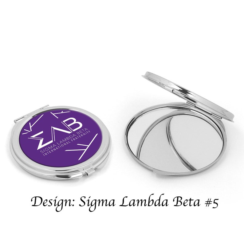 Pu&ograve; includere: Uno specchio compatto con un coperchio viola che presenta il logo della confraternita Sigma Lambda Beta e il testo "Sigma Lambda Beta International Fraternity".