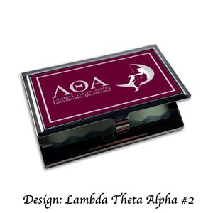 Puede incluir: Un porta tarjetas de plata con un inserto burdeos con un diseño de letras griegas blancas y el texto "ΛΘΑ Lambda Theta Alpha Latin Sorority, Incorporated".