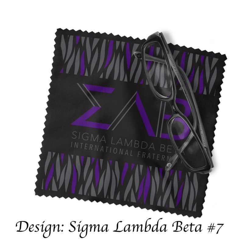 Może przedstawiać: Czarna ściereczka z mikrofibry z wzorem w pasy zebry w kolorze fioletowym i szarym. Ściereczka zawiera litery "&Sigma;&Lambda;&Beta;" w kolorze fioletowym i tekst "Sigma Lambda Beta International Fraternity".