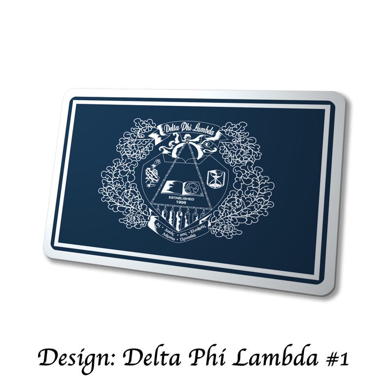May include: A navy blue rectangular design with a white border. The design features the words "Delta Phi Lambda" in a banner, along with a crest and the text "Established 1998". The text "Design: Delta Phi Lambda #1" is at the bottom.