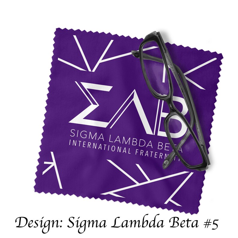 Może przedstawiać: Fioletowy ściereczka z mikrofibry do czyszczenia z białym logo Sigma Lambda Beta i tekstem "Sigma Lambda Beta International Fraternity". Na ściereczce leży para czarnych okular&oacute;w.