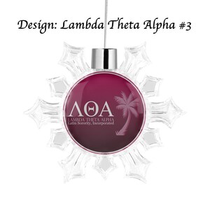 K&ouml;nnte beinhalten: Transparenter, schneeflockenf&ouml;rmiger Weihnachtsschmuck mit einem weinroten Mittelteil. In der Mitte befinden sich die griechischen Buchstaben &Lambda;&Theta;&Alpha; und eine Palmensilhouette mit dem Text "LAMBDA THETA ALPHA Latin Sorority, Incorporated." Der Text "Design: Lambda Theta Alpha #3" steht dar&uuml;ber.