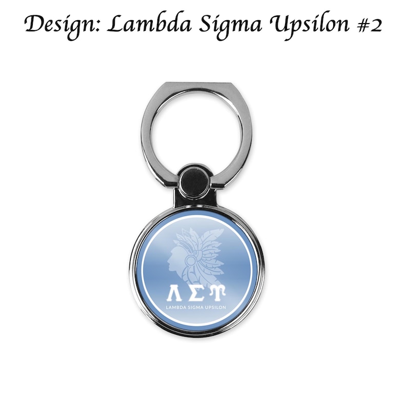 May include: A silver phone ring holder with a circular design on a light blue background. The design features a white silhouette of a person with a headdress, Greek letters &Lambda;&Sigma;&Tau;, and the text "LAMBDA SIGMA UPSILON". The text "Design: Lambda Sigma Upsilon #2" is at the top.