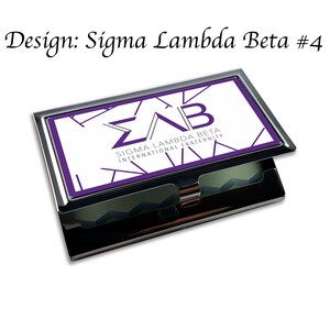 Puede incluir: Un porta tarjetas de visita de metal plateado con fondo blanco y un logotipo morado de Sigma Lambda Beta International Fraternity. El logotipo presenta las letras "&Sigma;&Lambda;&Beta;" en un dise&ntilde;o geom&eacute;trico.