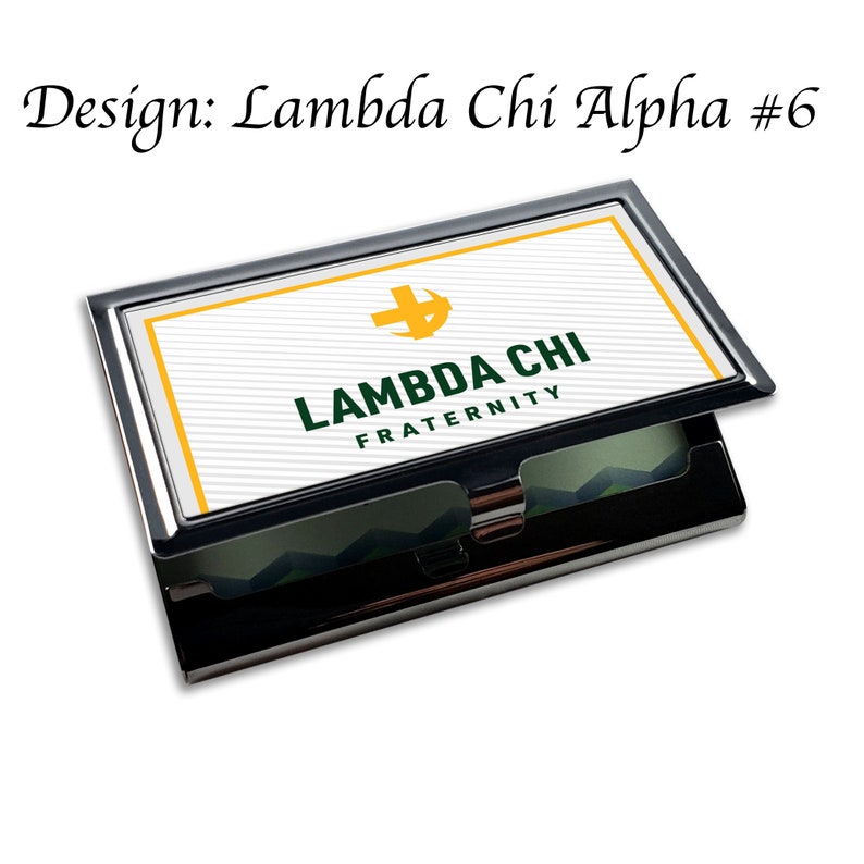 May include: A black and silver metal business card holder with a white background and a green and yellow logo that says 'Lambda Chi Fraternity'.