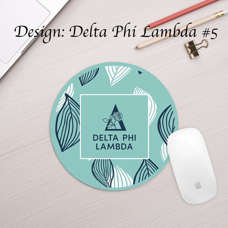 Może przedstawiać: Okrągła podkładka pod mysz w kolorze turkusowym z wzorem białych i czarnych liści. W środku znajduje się biały kwadrat z czarnym tr&oacute;jkątem i wzorem r&oacute;ży. Tekst "DELTA PHI LAMBDA" jest w czarnych literach wewnątrz kwadratu.