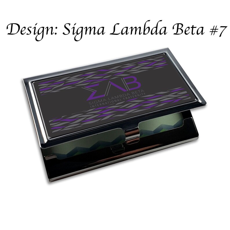 Puede incluir: Un porta tarjetas de visita negro y plateado con un dise&ntilde;o morado y gris. El dise&ntilde;o presenta las letras "&Sigma;&Lambda;&Beta;" y el texto "Sigma Lambda Beta International Fraternity".