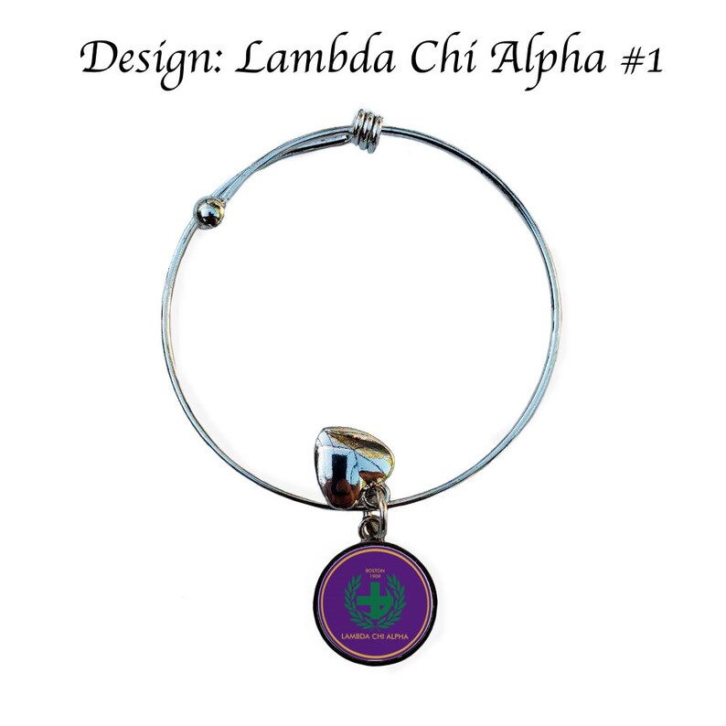 Puede incluir: Un brazalete extensible plateado con un dije que presenta un c&iacute;rculo morado con una corona de laurel verde y el texto "Lambda Chi Alpha" en letras doradas.