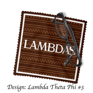 Könnte beinhalten: Ein braunes und weißes Stoffquadrat mit dem Wort "LAMBDAS" in weißen Buchstaben. Ein Paar schwarze Brillen liegt auf dem Stoffquadrat.